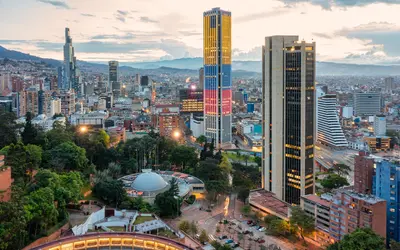 Bogotá skyline at sunset with high-rise buildings and surrounding mountains