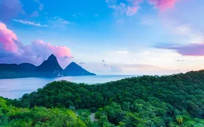 View of the Pitons from Jade Mountain Resort rising above tropical forest and coastline in Saint Lucia