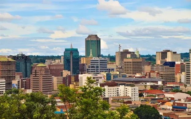 View of Harare, Zimbabwe, featuring modern office buildings and urban development under a partly cloudy sky.