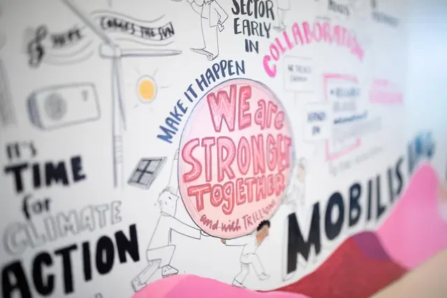 Illustrated conference mural created during the Global NDC Conference in Germany in 2023, featuring drawings, climate-related themes, and the message "We Are Stronger Together" alongside references to collaboration and climate action.