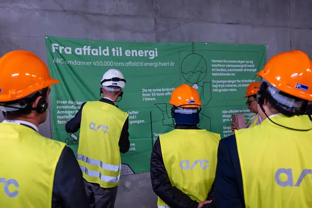 Participants wearing safety helmets and high-visibility vests during a site visit at the Copenhill waste-to-energy plant