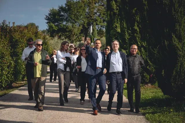 Participants walk through a landscaped outdoor site during a guided visit